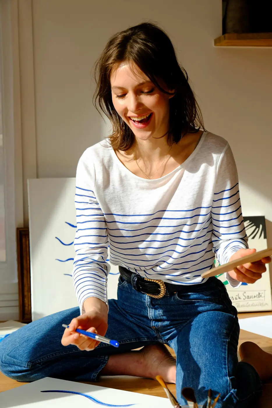 A woman smiling while painting